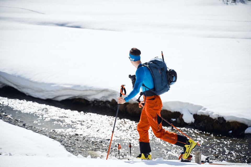© Fischer Sports GmbH Skier with backpack crossing snowy landscape. | © Fischer Sports GmbH
