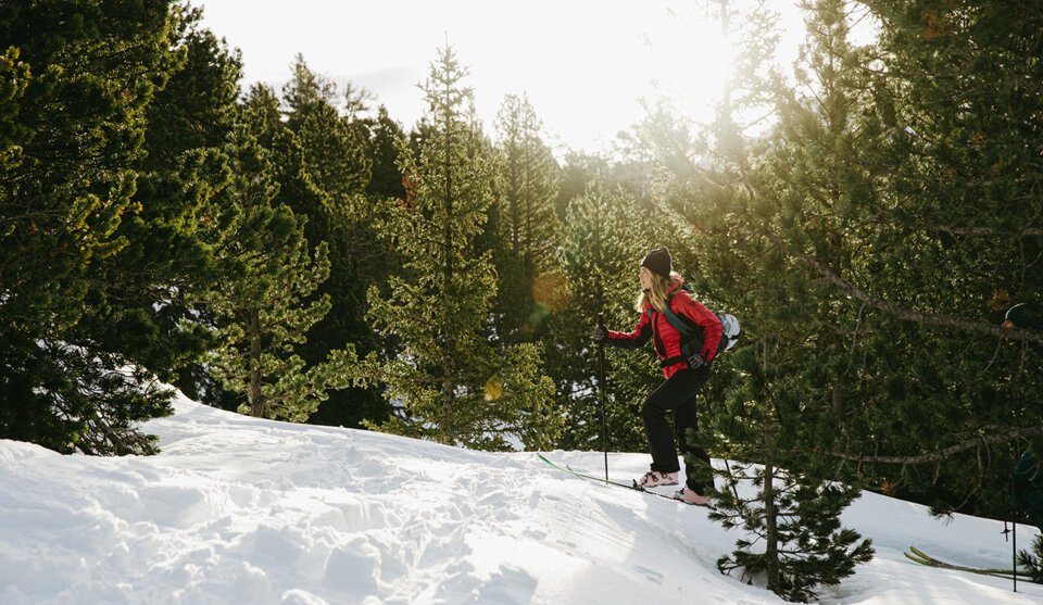 © Florian Monot / ROSSIGNOL Woman ski touring in snowy forest landscape. | © Florian Monot / ROSSIGNOL