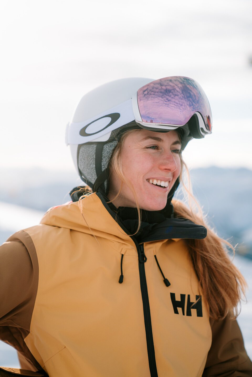 Woman smiling wearing ski helmet and goggles