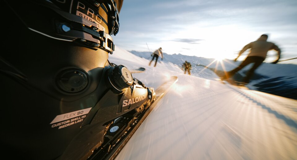 Ski boot and ski in motion on a snowy slope
